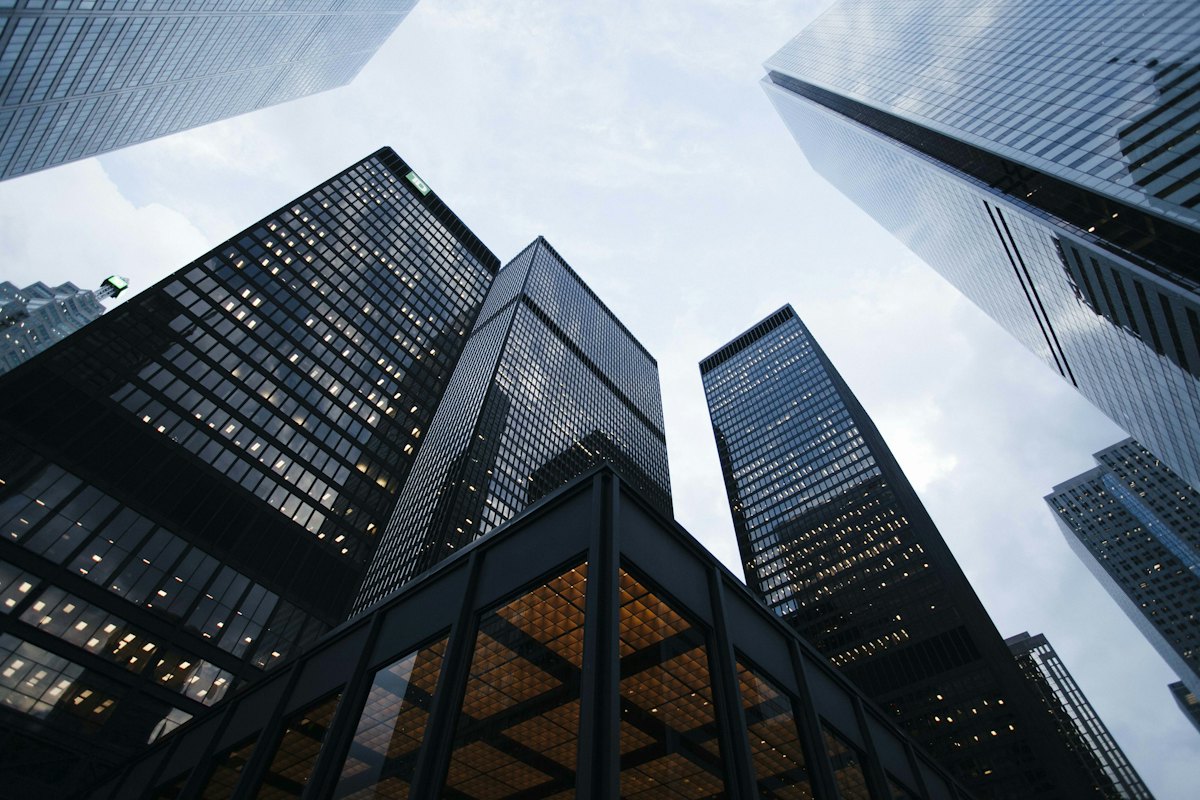 A low-angle view of modern skyscrapers against an overcast sky.